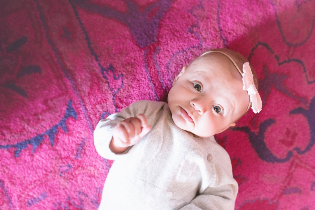 Silly baby girl on hot pink rug